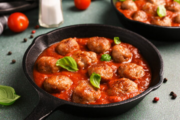.Meatballs with tomato sauce and basil in a frying pan