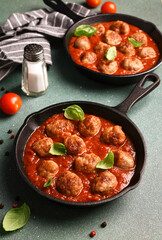 .Meatballs with tomato sauce and basil in a frying pan
