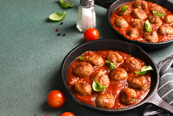 .Meatballs with tomato sauce and basil in a frying pan