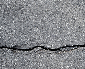 Earthquake disaster background. Cracks of road surface. Broken tarmac backdrop. Asphalt pavement damage.
