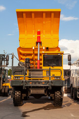 An orange mining dump truck with a raised body is parked © igor_zubkov