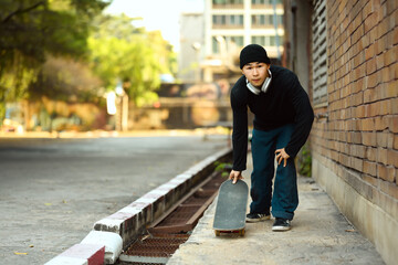 Young man with skateboard getting ready to skate in city street. Activity and lifestyles concept - Powered by Adobe
