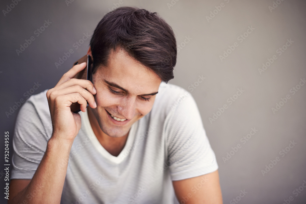 Poster Man, happy and phone call for talking in studio for communication on mobile network by background. Person, smartphone and listen with smile for chat, story or contact for conversation with connection