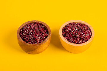 Red kidney beans in wood cup on yellow background