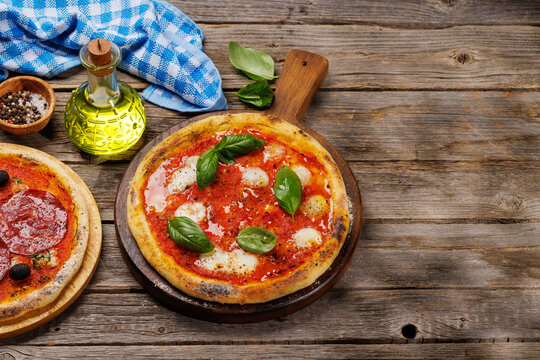Margarita and pepperoni pizza with tomatoes, mozzarella cheese and basil