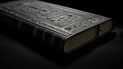 A black book with a silver cover on a table, suitable for educational or office themes