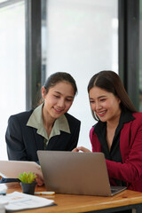 Businesspeople working at the office. Analyzing, discussing, and recording financial budget results, investments, project plans, and business operations based on graph documents chart into the laptop