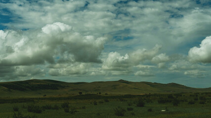 Photo of the steppe in summer, with beautiful clouds in the blue sky, the endless steppe at the...