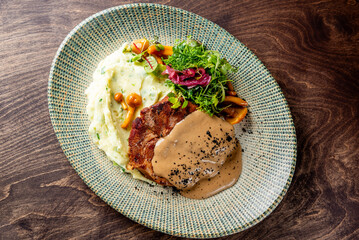 Grilled beef steak with mashed potato and sauce in plate