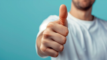 Close up man in a light shirt showing thumbs up gesture on a pastel blue background - obrazy, fototapety, plakaty