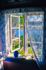 Open window in an old cottage with lake view in summer - obrazy, fototapety, plakaty