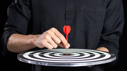 Businessman throwing red arrow dart to  target dart board. Setup objectives and target for business...