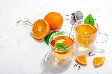 Orange tea in glass cups with ripe fruits. Refreshment seasonal drink, conceptual background