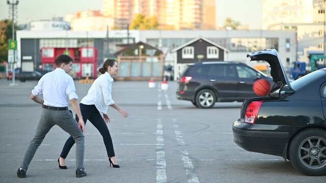 two Young office workers or students playing basketball in a supermarket parking lot