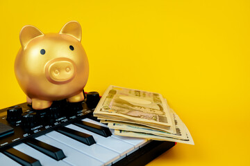 Piano keys and piggy bank on a yellow background