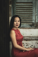 Naklejka premium Woman wearing traditional Vietnamese ao dai walking on the road of flying tamarind leaves.Portrait of woman wearing black sunglasses while standing behind friend.