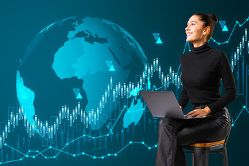 Attractive happy young european woman sitting on chair with laptop and creative globe hologram with growing forex chart on blue background. Global business, international stock market concept.