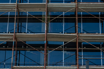Modern Building Under Construction. Scaffolding, Glass Facade, Exterior Design.
