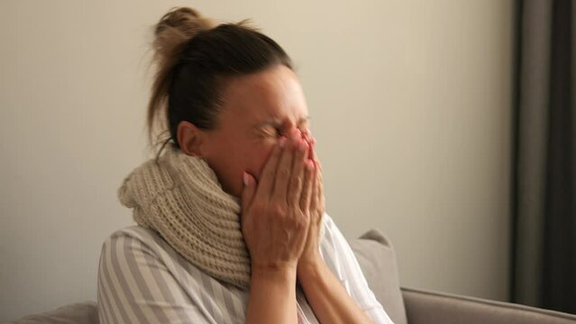 Woman at home battles flu evident in persistent coughs frequent sneezes and fever With flu symptoms worsening she prioritizes rest for recovery Flus impact underscores importance of during illness