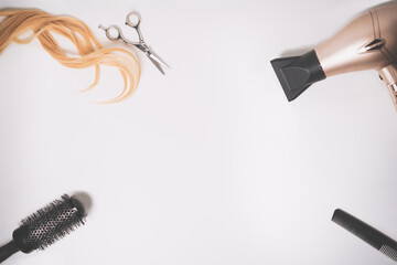 Hairdresser tools and piece of blonde hair comb on the white background with copy space. Isolated on white.