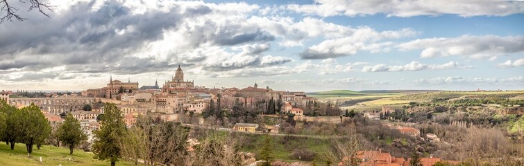 Panoramic view of Segovia from which we can see the Cathedral and the famous aqueduct of the city with a cloudy sky on a winter sunset