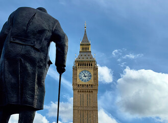Rear view of the statue of Sir Winston Churchill overlooking Big Ben in Parliament Square, Westminster, London, UK. 