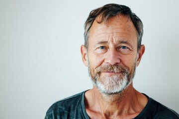 Obraz premium mid age man portrait looking at camera, head shot of happy mature man on gray studio background
