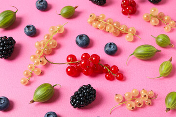 Ripe berries on the table on a pink background.