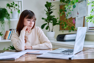 College student teenage girl sitting at desk with computer laptop