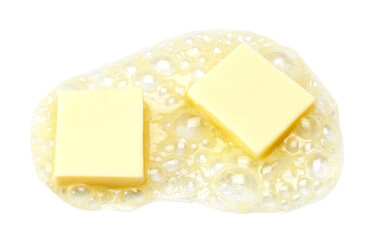 Two pieces of butter melting isolated  on white background