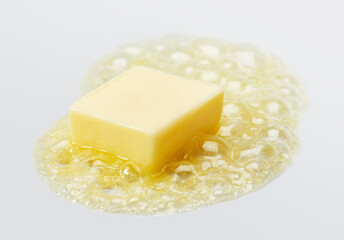Butter melting over grey background