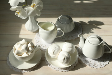 Spring breakfast with marshmallow, coffee and milk. Flatlay with food and flower in white color