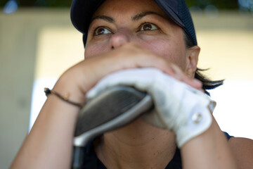 Thinking Golfer with a Cap Leaning on Her Golf Club in a Sunny Day in Switzerland.