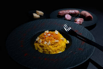 Elegant Plate with Saffron Risotto alla Milanese and Luganighe with Parmesan Cheese in Lugano, Ticino, Switzerland.