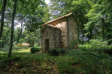 Church of St. Marine of Zegaani monastery. Surrounded by trees and bushes, standing on a green field. Illuminated by the sun's rays.