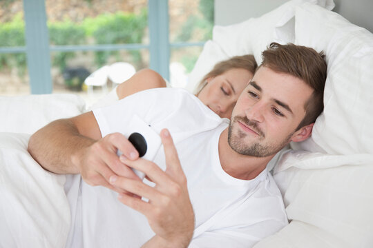 Man in Bed Using Smartphone
