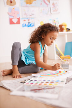 Kindergarten, education or girl painting a rainbow on classroom floor for creative, learning or child development. Paper, color splash or sweet kid with school art paint, sketch or having fun drawing