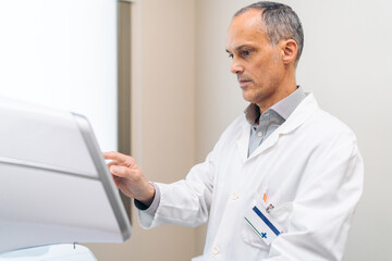 An ophthalmologist fine-tunes a laser machine for an upcoming surgery.
