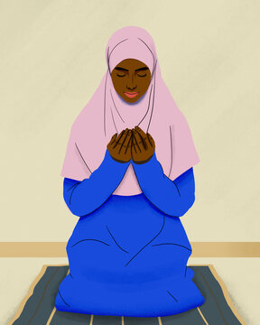 Muslim woman in hijab praying on mat
