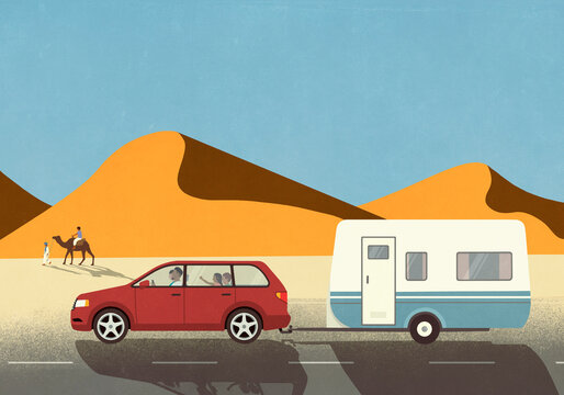 Family in car on vacation, pulling camper trailer along sand dunes in desert
