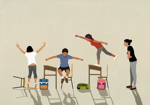 Angry school teacher watching unruly, hyper schoolchildren jumping on desks in classroom
