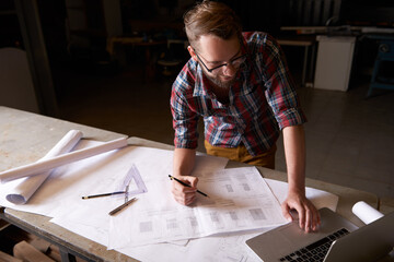 Man, architect and laptop or blueprint, working and planning for construction. Architecture,...