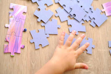 little child assembling puzzles, sorting cardboard pieces by shape, assemble puzzles, cognitive...