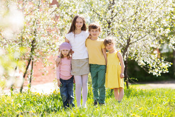 Fototapeta premium group kids friends spend time together in a flowering garden in spring.