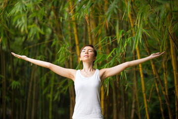 Chinese woman practicing yoga outdoors.