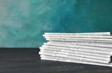 Stack of newspapers on wooden table. Journalist's work