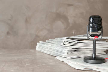 Newspapers and vintage microphone on marble table, space for text. Journalist's work - obrazy, fototapety, plakaty