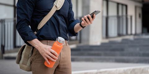 Businessman walking to work while to hold reusable eco friendly ecological cup in the city