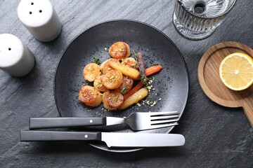 Delicious fried scallops served on dark gray textured table, flat lay