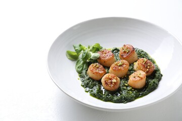 Delicious fried scallops with tasty sauce and corn salad in bowl on white table, closeup